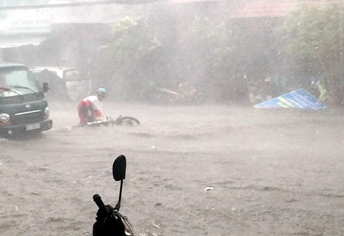 Nhiều người đi đường té ngã do mưa lớn ở Biên Hòa. Ảnh: Thái Hà/VnExpress.