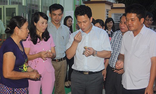 Ông Đặng Quốc Khánh (thứ 4 từ trái qua) thưởng thức cá nướng với tiểu thương tại cửa hàng kinh doanh ở đường Võ Liêm Sơn (TP Hà Tĩnh). Ảnh: D.T.