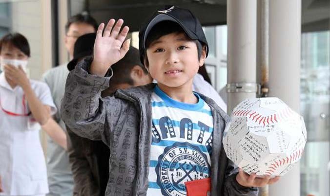 Yamato Tanooka vẫy tay chào các nhà báo khi xuất viện về nhà hôm 7/6. Ảnh: Reuters.