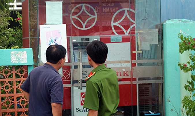 Cảnh sát khám nghiệm hiện trường máy ATM bị trộm. Ảnh: Hồ Nam.