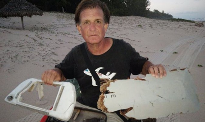 Ông Blaine Gibson và các mảnh vỡ khả nghi mới tìm thấy ở Madagascar. Ảnh: BBC.