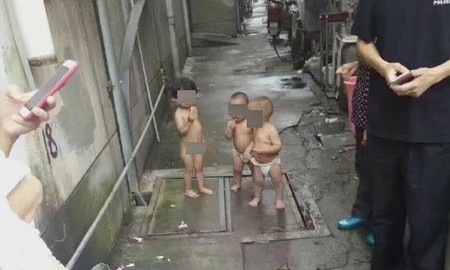 Bé gái 2 tuổi trần truồng dẫn theo hai đứa em sinh đôi đi ra ngoài đường. Ảnh: Shanghaiist.