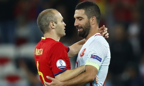 Iniesta (trái) và Arda Turan ôm nhau sau trận đấu. Ảnh: Reuters.