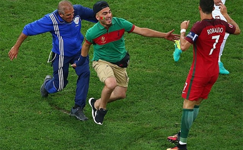 Karimi liều lĩnh lao vào sân và tóm được áo của thần tượng. Ảnh: AFP.