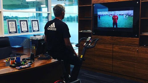 HLV Mourinho đang xem TV trong phòng làm việc.
