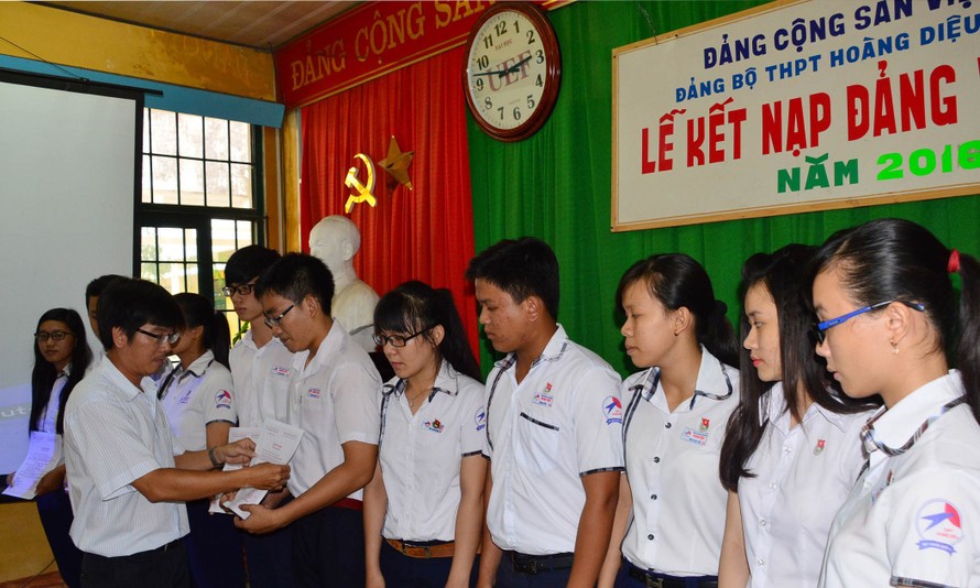 Thầy Trần Ngọc Nguyên –Phó Bí thư Đảng ủy nhà trường trao quyết định kết nạp Đảng cho các học sinh trường PTTH Hoàng Diệu