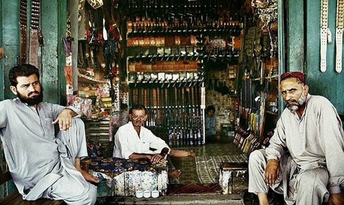 Ba người đàn ông ngồi trong một cửa hàng bán vũ khí ở ngôi làng Darra Adam Khel. Ảnh: Amusing Planet.