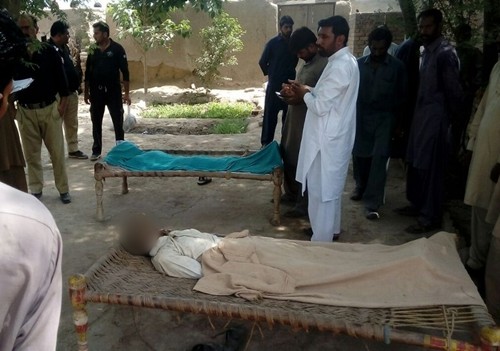Cảnh sát đứng cạnh thi thể một phụ nữ và người nghi là bạn trai bị cha, anh trai và chồng của cô treo cổ ở làng Chak 56, gần thành phố Multan, Pakistan, ngày 15/9. Ảnh: AFP.