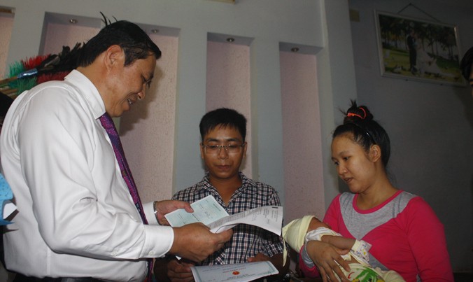 Cháu bé đầu tiên được nhận giấy khai sinh tại nhà do chính Chủ tịch UBND TP trao. Ảnh: Nguyễn Thành.