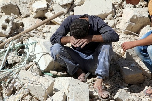 Một người đàn ông mất đi người thân sau một đợt không kích ở khu al-Qaterji, Aleppo, ngày 11/10. Ảnh: Reuters.