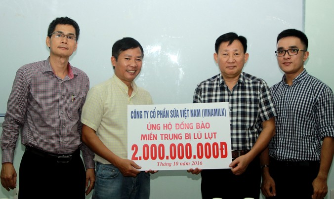 Ông Nguyễn Thanh Tú (thứ 2, từ phải sang) thay mặt 6.000 cán bộ, công nhân viên Công ty Vinamilk trao tiền ủng hộ người dân bị mưa lũ.