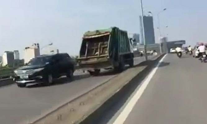 Xe chở rác ngang nhiên đi ngược chiều trên cầu vượt Mễ Trì (Hà Nội). Ảnh: Cắt từ clip.