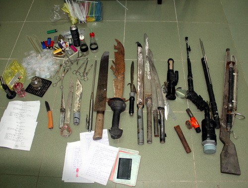 Nhiều súng, mã tấu, dao... được tìm thấy trong nhà hai vợ chồng bán ma túy. Ảnh: Hồng Tuyết.