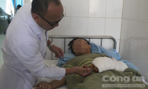 Bác sỹ Phùng Văn Hà kiểm tra vết thương của bệnh nhân sau khi phẫu thuật.
