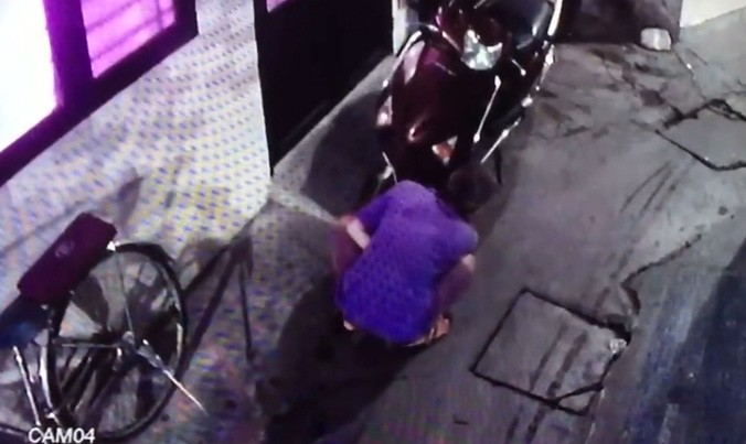 Người đàn ông đang cắt trộm heo dầu thắng đĩa xe tay ga. Ảnh cắt từ clip. 