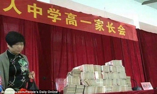 Hình ảnh núi tiền bao gồm nhiều tệp 100 nhân dân tệ xếp chồng trên bàn được chia sẻ rầm rộ trên mạng xã hội Trung Quốc. Ảnh: Huanqiu.