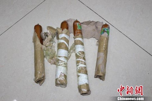 4 cây xúc xích được bọc giấy và cột lại với nhau, tạo thành một quả bom giả để chàng trai dọa người yêu cũ. Ảnh: China News.