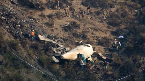 Các nhà điều tra Pakistan kiểm tra hiện trường máy bay rơi hôm qua. Ảnh: AP.