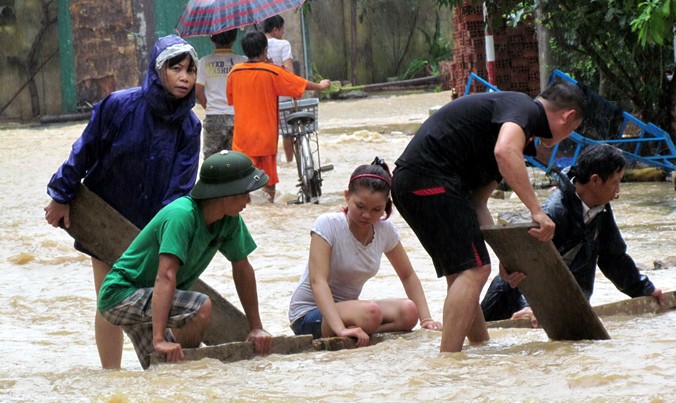 Người dân mang vật liệu chắn nước lũ gây sạt lở, ở đường Ngô Văn Sở.