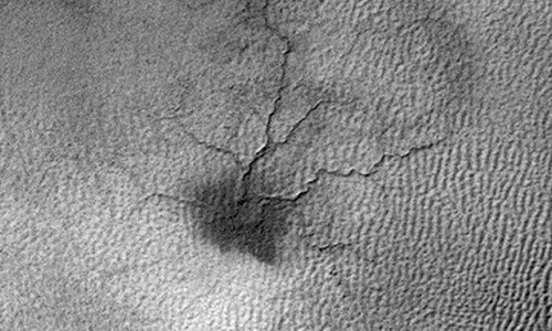 Những đường rãnh tỏa ra từ hố lõm ở trung tâm tạo thành vùng "con nhện" trên sao Hỏa. Ảnh: NASA.