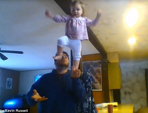Cô bé 1,5 tuổi rất tự tin khi giữ thăng bằng trong lòng bàn tay cha.