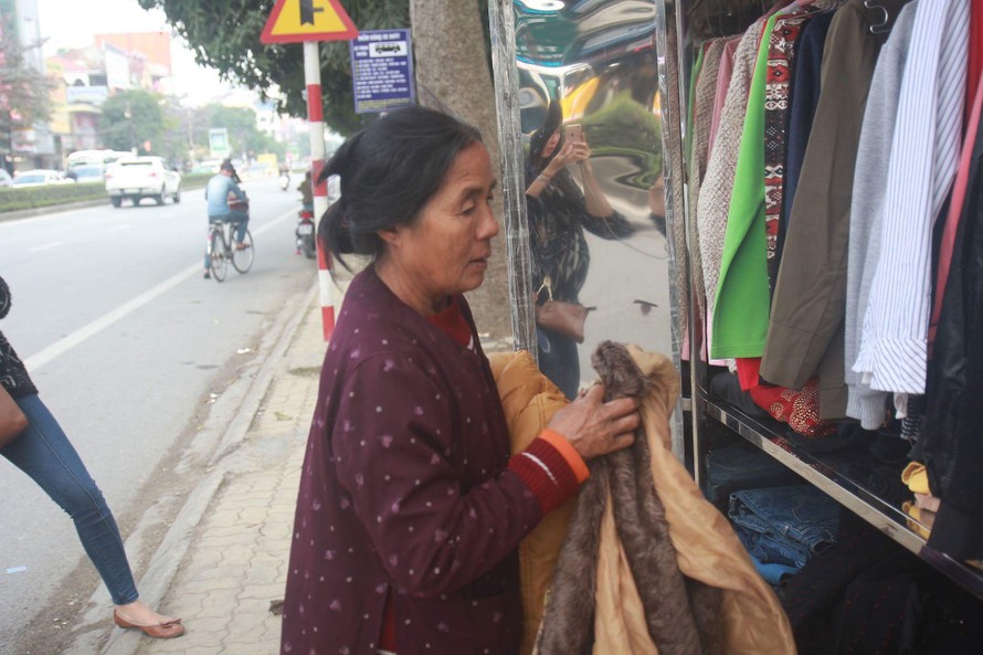 Một người lao động nghèo đang đến tủ quần áo miễn phí để chọn những bộ đồ ưng ý về cho mình và gia đình.
