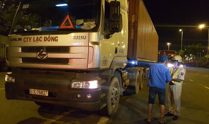 Lực lượng chức năng xử lý xe container đang đậu đỗ sai quy định tại giao lộ Nguyễn Văn Linh – Nguyễn Thị Thập.