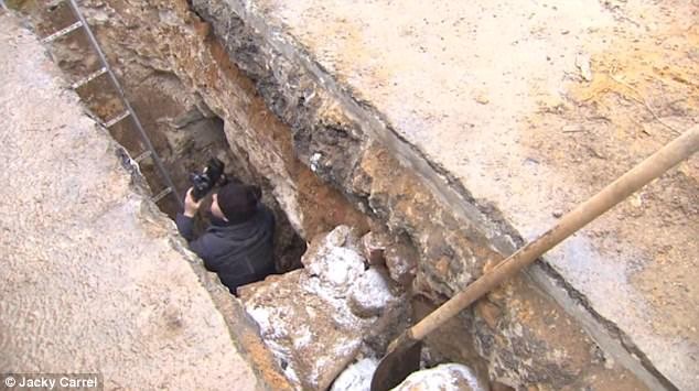 Nhà khảo cổ đang chụp hình hầm ngầm.