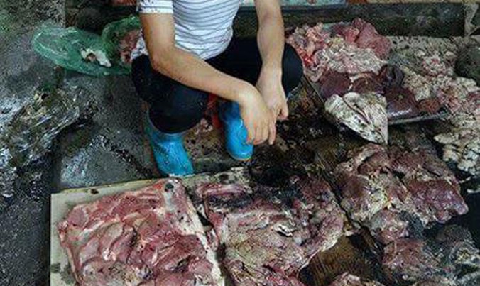 Chị Xuyến cùng khoảng 50kg thịt lợn bị hắt dầu luyn trộn với chất thải. Ảnh cắt từ video.