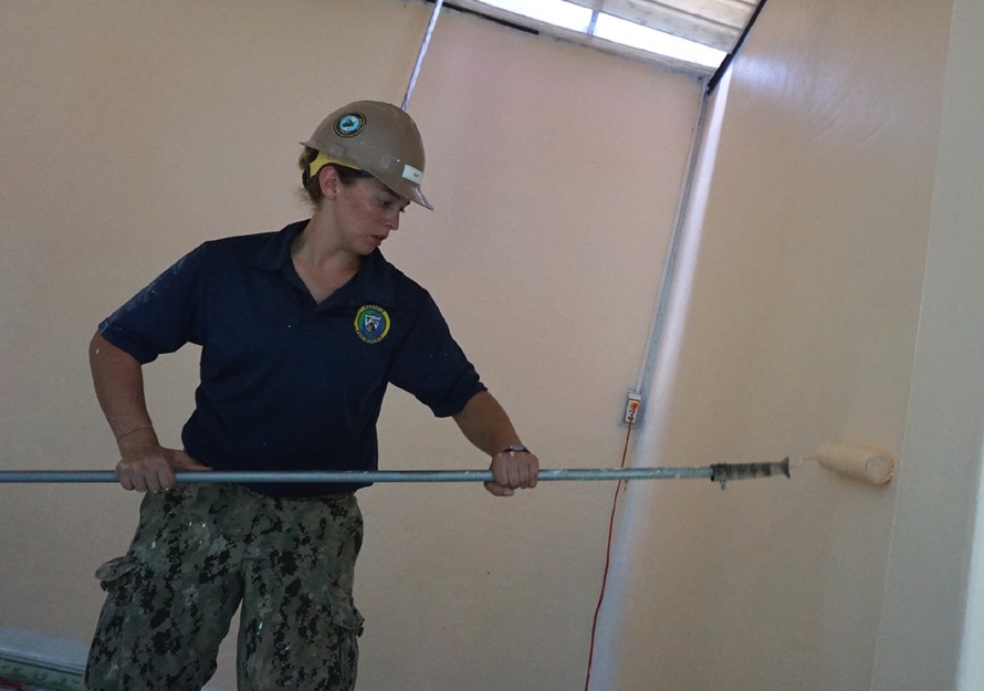 Nữ hạ sĩ quan Hải quân Hoa Kỳ Sabrina Gruett, 25 tuổi đang sơn tường một phòng học.