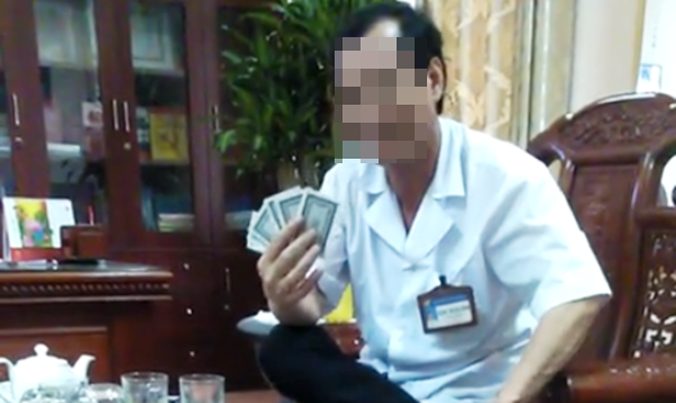 Hình ảnh ông Đặng Trung Bình, Giám đốc BVĐK huyện Gia Viễn mặc áo blouse trắng ngồi đánh bài ăn tiền bị tung lên mạng xã hội.