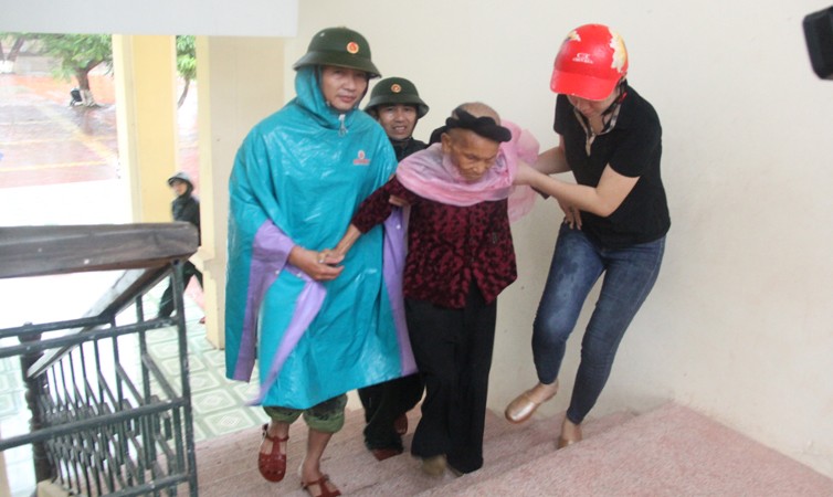 Lãnh đạo UBND huyện Nghi Xuân cùng đội ngũ y tế, đoàn viên thanh niên giúp đỡ các cụ già được sơ tán an toàn tại trường Tiểu học xã Xuân Hội.
