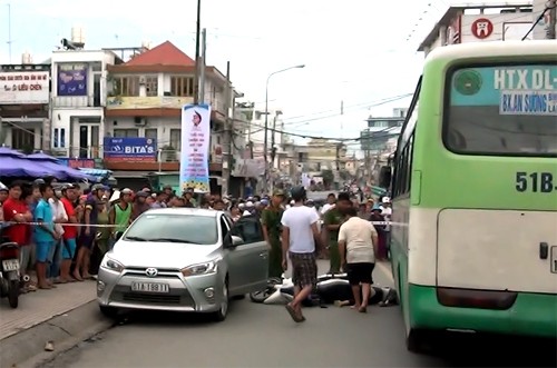 Cô gái bị xe buýt cán tử vong sau khi ôtô đang đậu mở cửa bất ngờ. Ảnh: Nguyệt Triều.