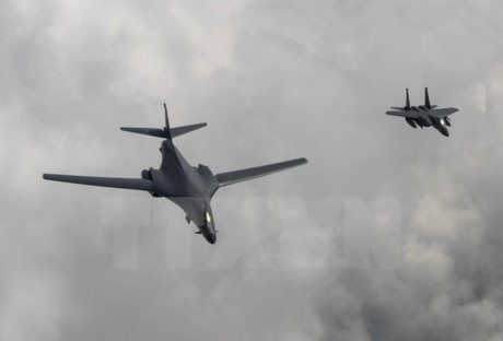 Máy bay ném bom B1-B của Mỹ (trái) thực hiện hành trình bay 10 giờ từ Căn cứ không quân Andersen, đảo Guam đến bán đảo Triều Tiên ngày 30/7 vừa qua. Ảnh: EPA/TTXVN.