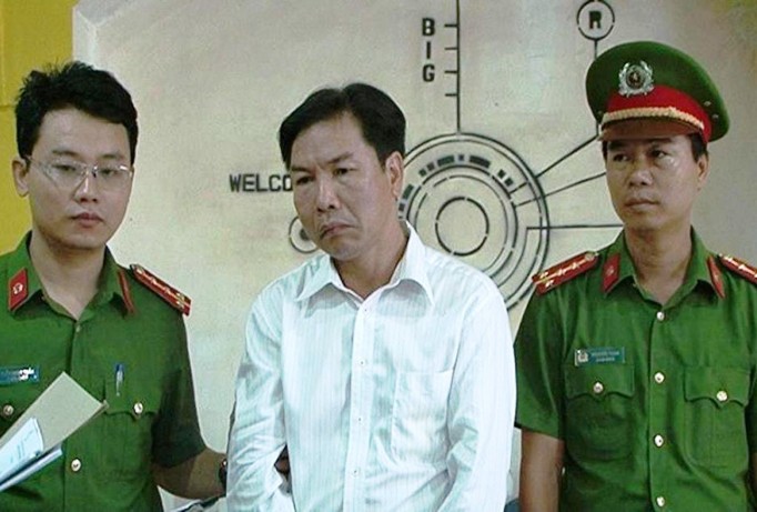 Thi hành lệnh bắt tạm giam đối với Lê Hữu Lam (áo trắng), nguyên giám đốc một trung tâm thuộc Ban quản lý Khu Kinh tế Chân Mây-Lăng Cô (tỉnh TT-Huế).