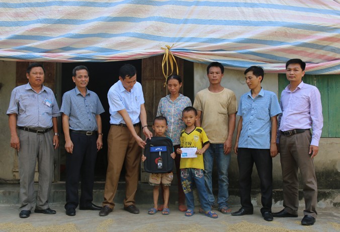 Đồng chí Đặng Thọ Xuân , Phó chủ tịch UBND huyện Tân Kỳ trao quà học sinh nghèo.
