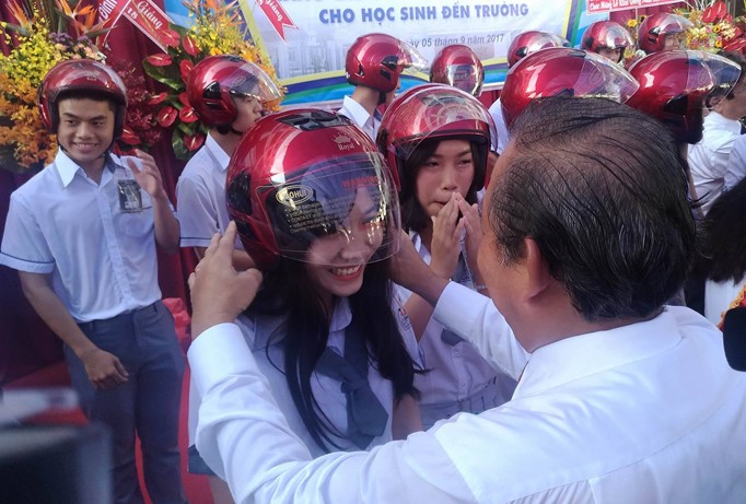Ủy viên Bộ Chính trị, Phó Thủ tướng Thường trực Chính phủ Trương Hòa Bình trực tiếp đội mũ cho học sinh phát động tháng cao điểm an toàn giao thông.