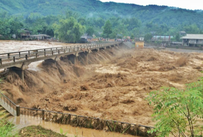 Cây cầu bắc vào bản Noong, Pú Trạng, thị xã Nghĩa Lộ đang bị đe doạ nghiêm trọng bởi lũ dữ.