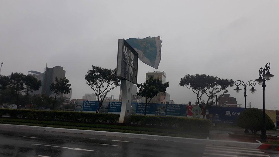 Một tấm biển chào mừng APEC tiếp tục bị gió xé rách.