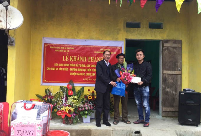 Đại diện báo Tiền Phong tại Lạng Sơn (bìa trái) tặng hoa, quà mừng ông Chéo có ngôi nhà khang trang. Ảnh: Duy Chiến.