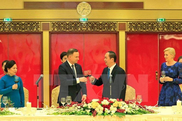 Chủ tịch nước Trần Đại Quang và Phu nhân cùng Tổng thống Cộng hòa Ba Lan Andrzej Duda và Phu nhân nâng cốc. Ảnh: Nhan Sáng/TTXVN.