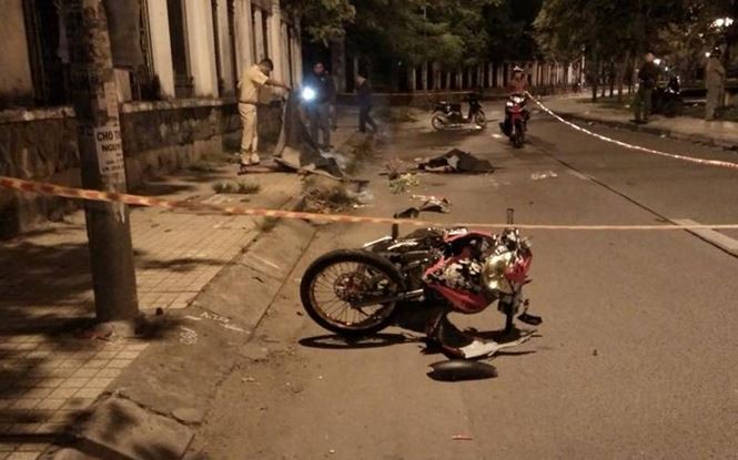 Chiếc xe máy hư hỏng bên thi thể hai nạn nhân.