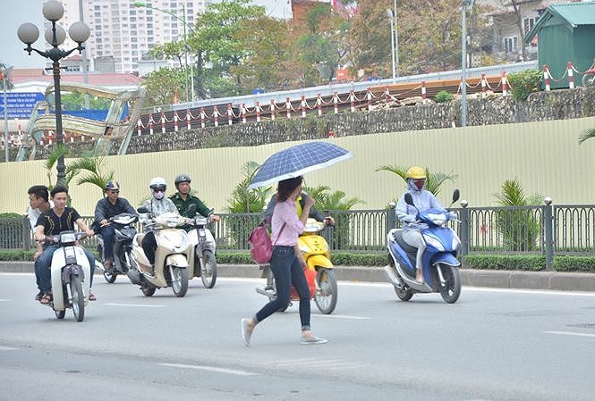 Người đi bộ qua đường nơi không có vạch sơn, biển báo. Ảnh: Thanh Hà