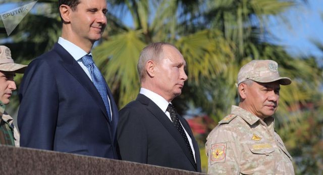 Tổng thống Nga Vladimir Putin (giữa) gặp người đồng cấp Syria Assad (trái) khi đến thăm căn cứ Khmeimim. Ảnh: Sputnik.