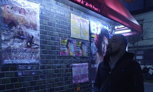 Một người đàn ông đi qua bức tường dán đầy quảng cáo mại dâm nam ở Nicho, Tokyo. Ảnh: SCMP.