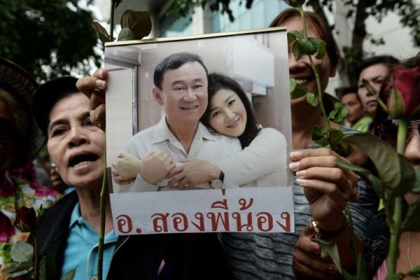 Người ủng hộ cầm ảnh ông Thaksin và em gái Yingluck tại Bangkok hồi tháng 8/2017. Ảnh: AFP.