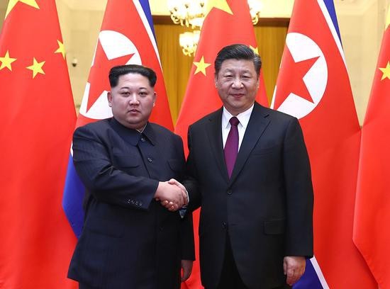 Nhà lãnh đạo Triều Tiên Kim Jong-un bắt tay Chủ tịch Trung Quốc Tập Cận Bình tại Bắc Kinh. Ảnh: Xinhua.