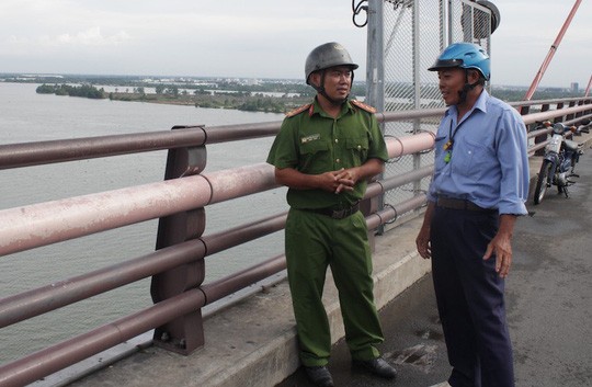 Đại uý Nguyễn Minh Nhựt nói chuyện với bảo vệ cầu Cần Thơ về việc giữ gìn an ninh trật tự trên cầu.