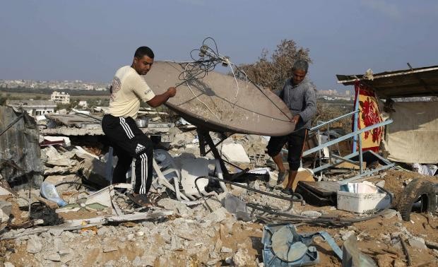 Người Palestine trong đống đổ nát vì bom đạn của Israel