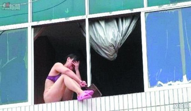Nạn nhân ngồi trên cửa sổ trước khi tự tử. Ảnh: Shanghaiist